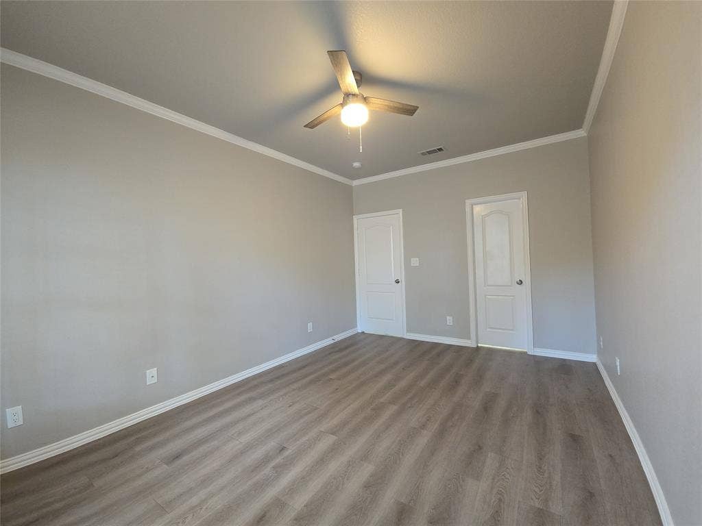 1501 Cedar Elm Drive, #102, Euless, TX 76039 Wood-finish flooring, crown molding, ceiling fan with integrated lighting, and two panel doors