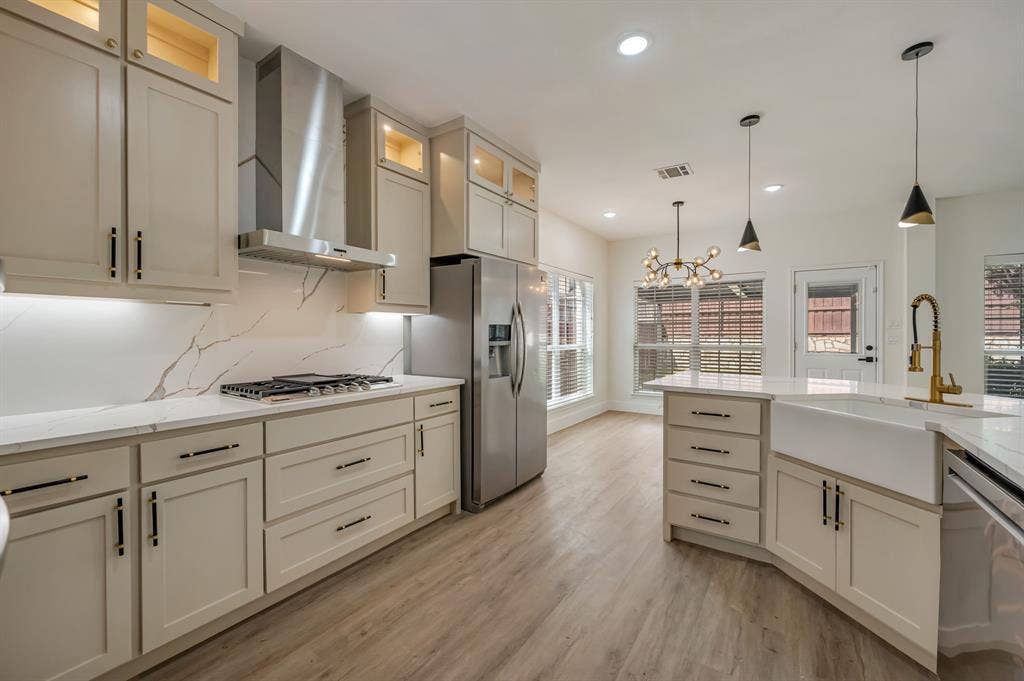 7904 Blacktail Trail, McKinney, TX 75070 Modern kitchen featuring light-toned cabinetry, stainless steel appliances, a farmhouse sink, and Luxury Vinyl Plank flooring