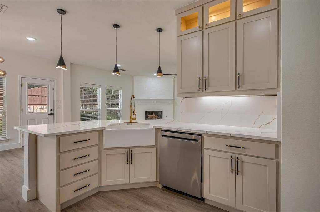 7904 Blacktail Trail, McKinney, TX 75070 Kitchen with light-toned cabinetry, a farmhouse sink, stainless steel dishwasher, Quartz countertops with gold veining, and pendant lighting