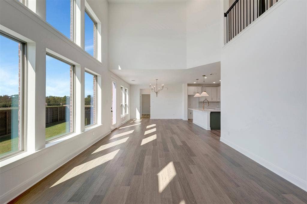 1616 Compass Heights, Mesquite, TX 75181 Two-story living area with high ceilings, wood-finish flooring, and multiple large windows