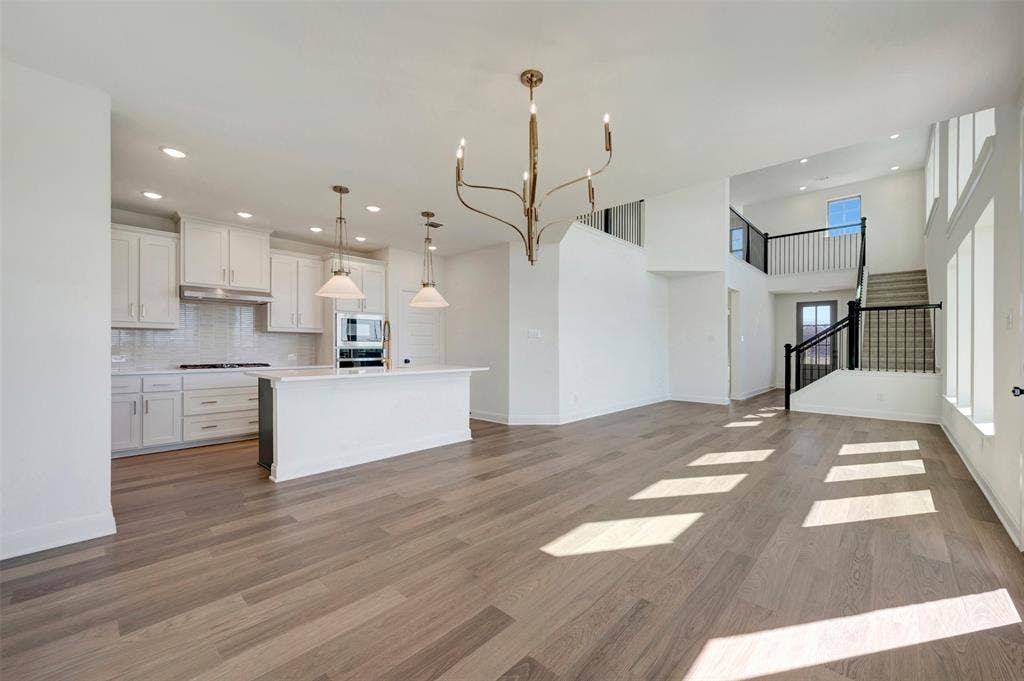 1616 Compass Heights, Mesquite, TX 75181 Open-concept living area featuring wood-finish flooring and high ceilings