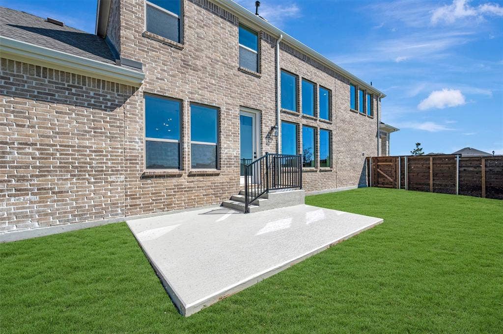 1616 Compass Heights, Mesquite, TX 75181 Brick exterior with multiple windows, concrete patio, green lawn, and wood privacy fencing