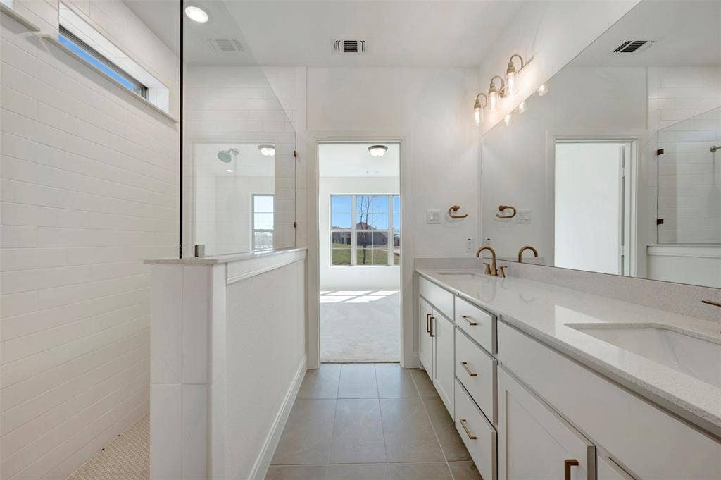 1616 Compass Heights, Mesquite, TX 75181 White tile flooring, dual vanities with integrated sinks, white cabinetry, and brushed gold fixtures