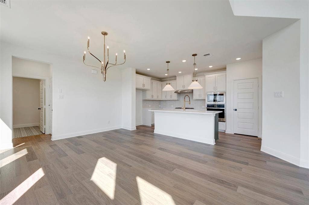 1616 Compass Heights, Mesquite, TX 75181 Open-concept living area with wood-finish flooring, a contemporary chandelier, and recessed lighting