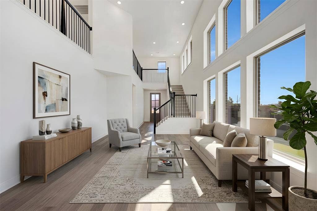 1616 Compass Heights, Mesquite, TX 75181 Two-story living area with soaring ceilings, expansive windows, wood-finish flooring, and a multi-level staircase with open railings