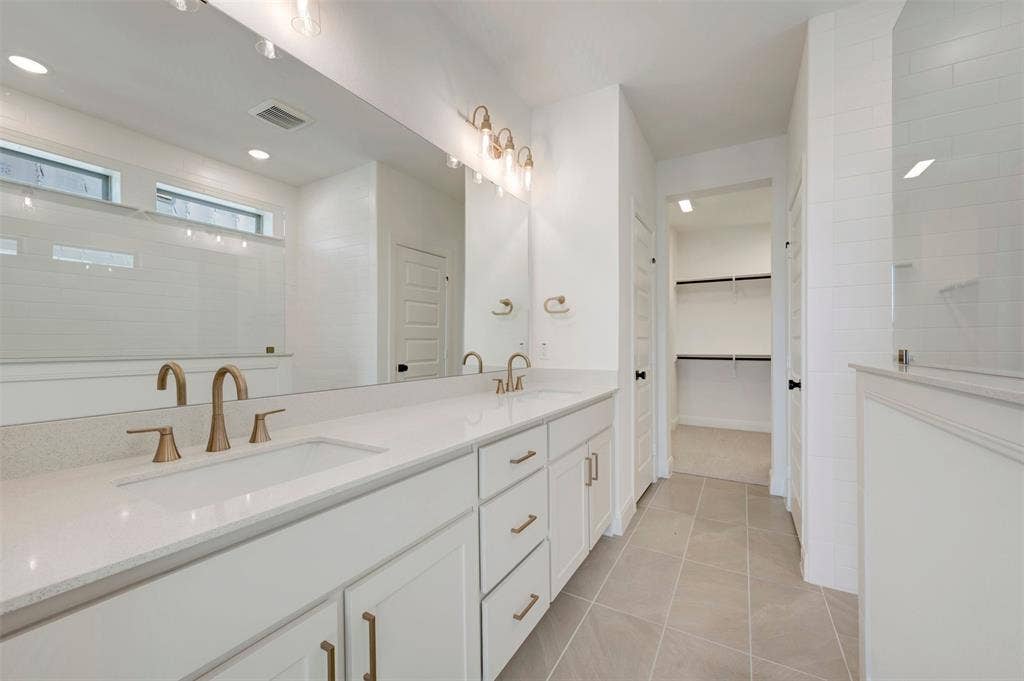 1616 Compass Heights, Mesquite, TX 75181 Dual vanity with undermount sinks, bronze finish fixtures, and white cabinetry