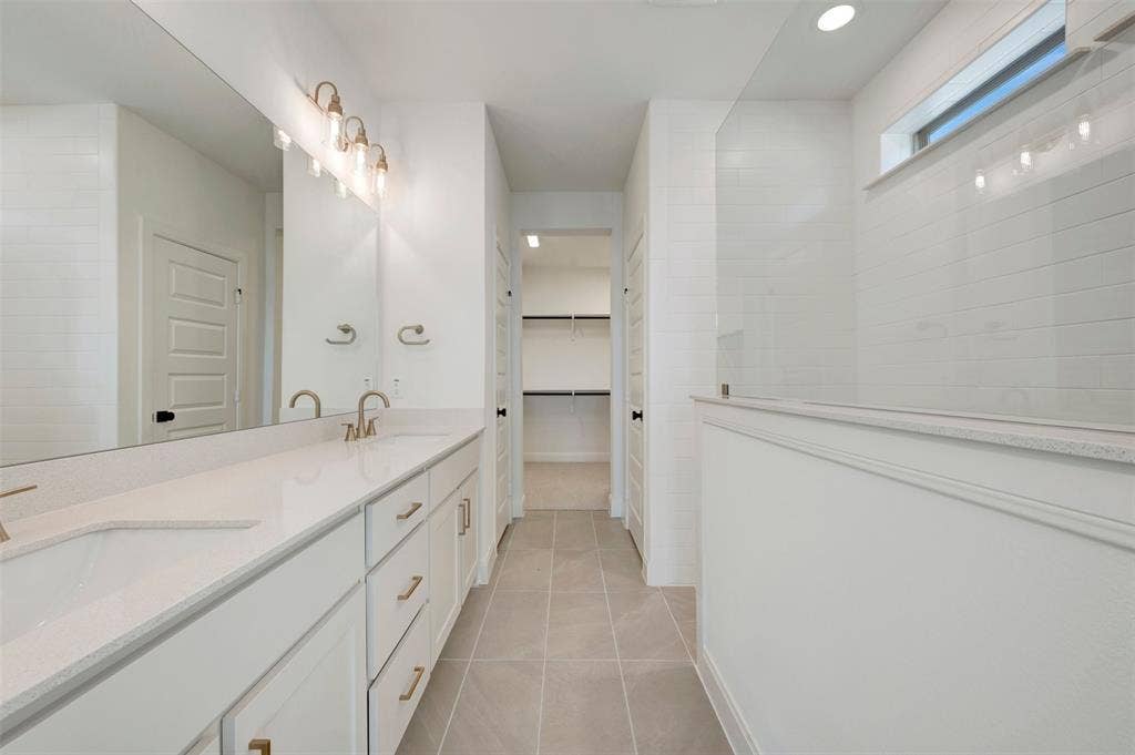 1616 Compass Heights, Mesquite, TX 75181 Double vanity with integrated sinks, white cabinetry, and gold-finish hardware