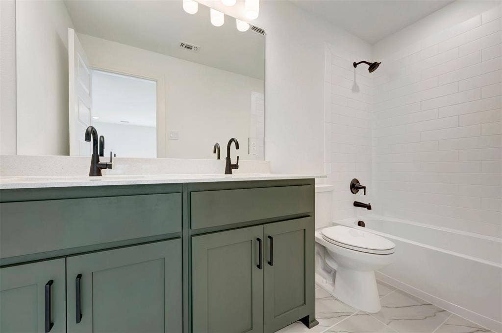 1616 Compass Heights, Mesquite, TX 75181 Dual vanity with dark green cabinetry and a light-toned countertop, featuring matte black fixtures