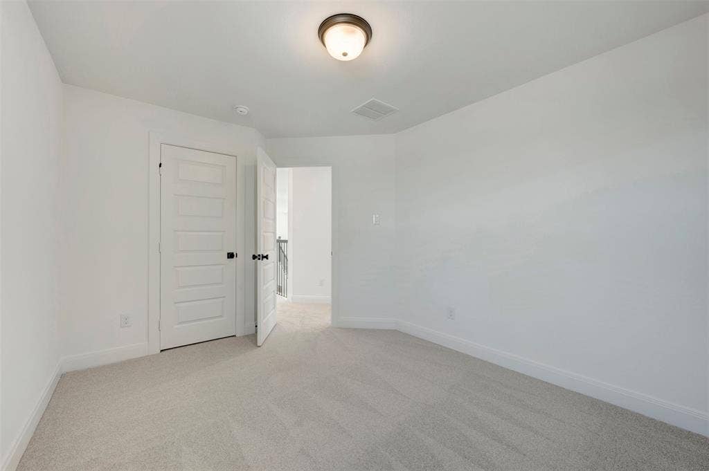 1616 Compass Heights, Mesquite, TX 75181 Neutral paint palette with light-colored carpet flooring, recessed lighting, and a paneled door with dark hardware