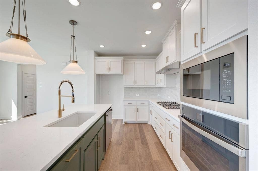 1616 Compass Heights, Mesquite, TX 75181 White shaker cabinetry, light wood-finish flooring, stainless steel appliances, recessed lighting, and a kitchen island with an undermount sink