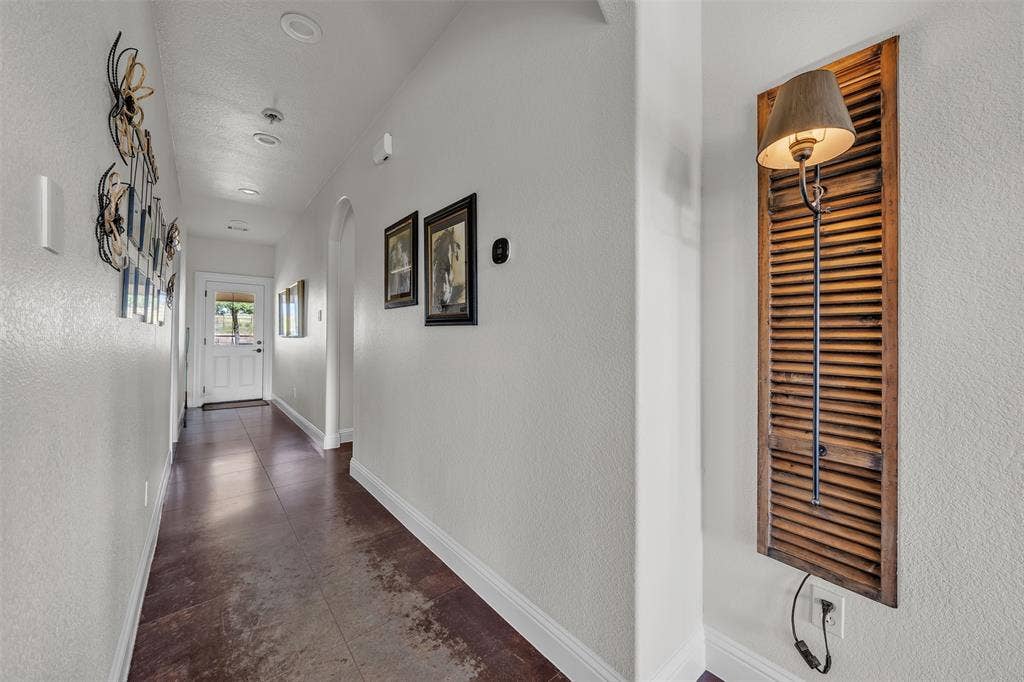 Hallway featuring recessed lighting, a paneled entry door with glass inserts, and wood-finish flooring