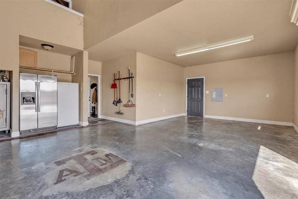 Expansive concrete flooring with a distinct graphic, high ceilings, and recessed lighting
