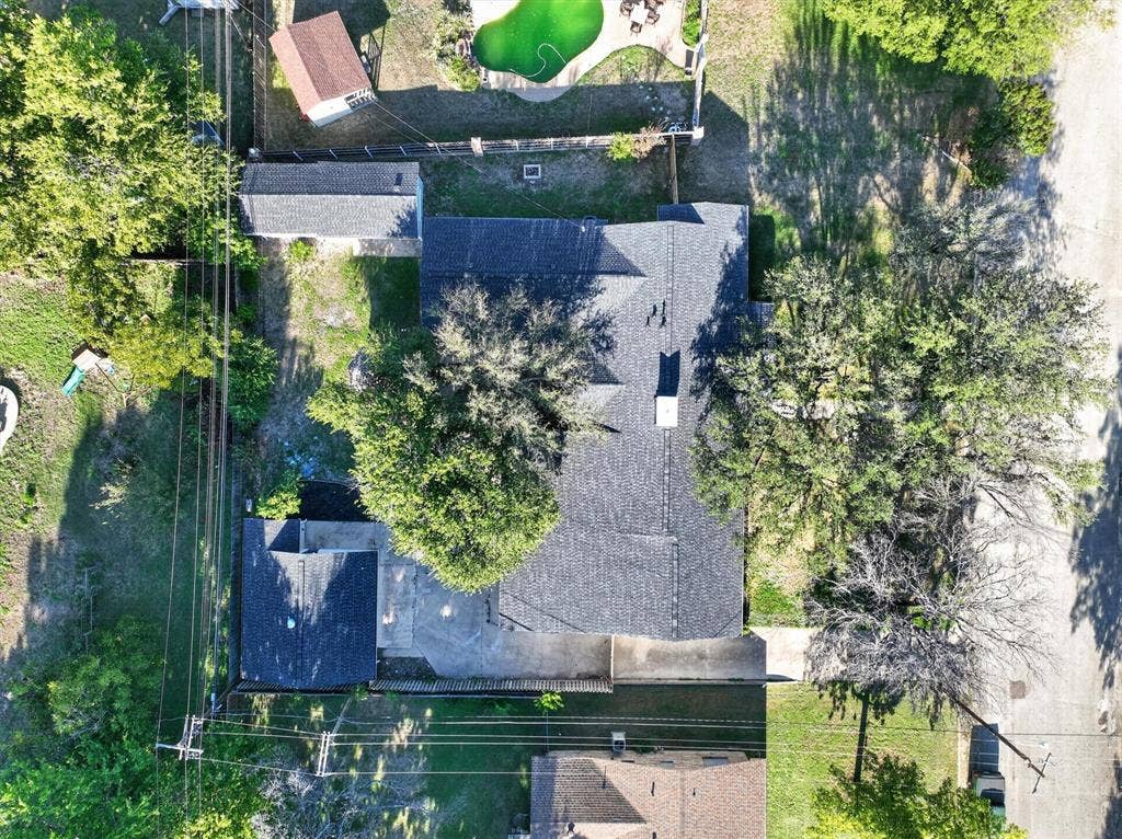 1204 Loma Alta Place, Cleburne, TX 76033 Asphalt shingle roof, mature trees, concrete driveway, and a detached structure
