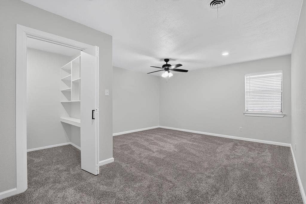 1204 Loma Alta Place, Cleburne, TX 76033 Neutral gray walls, plush gray carpet, ceiling fan, recessed lighting, and built-in shelving