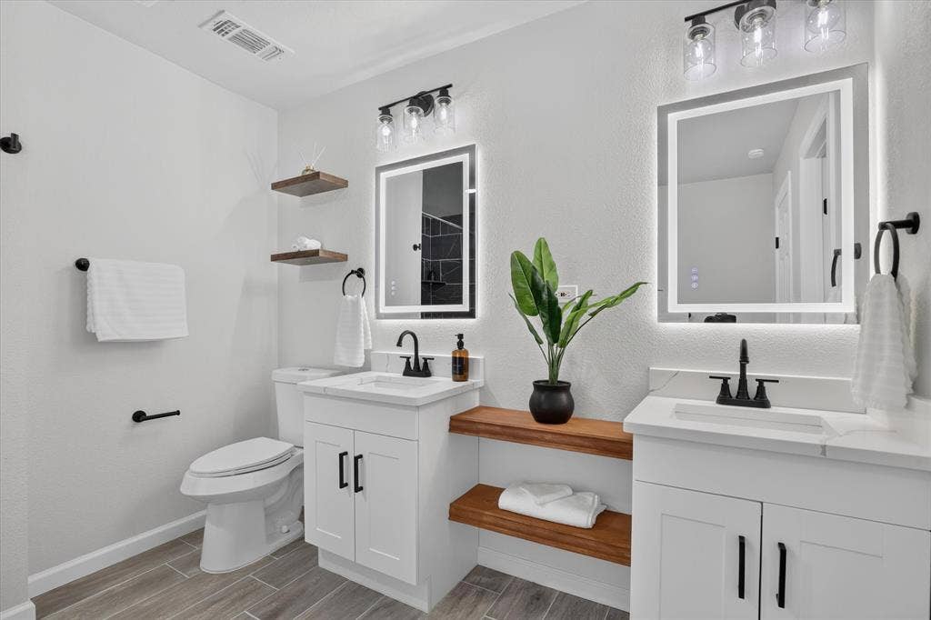 1204 Loma Alta Place, Cleburne, TX 76033 Dual vanity with white cabinetry, matte black hardware, and integrated sinks
