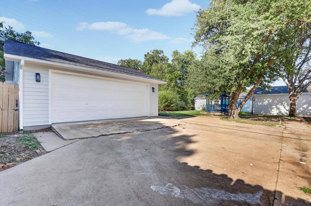 1204 Loma Alta Place, Cleburne, TX 76033 White paneled garage door with wall-mounted exterior lighting