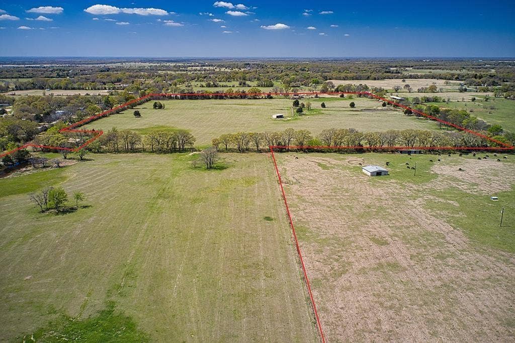00 Tx-274 Highway, Kemp, TX 75143 Expansive agricultural land featuring a clear-span metal building, mature trees, and a visible property boundary