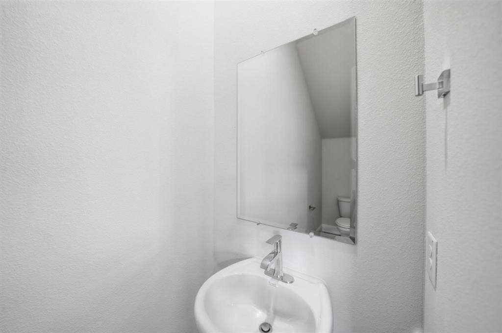 4532 Community Court, Plano, TX 75024 Wall-mounted mirror over a white porcelain pedestal sink with a chrome faucet