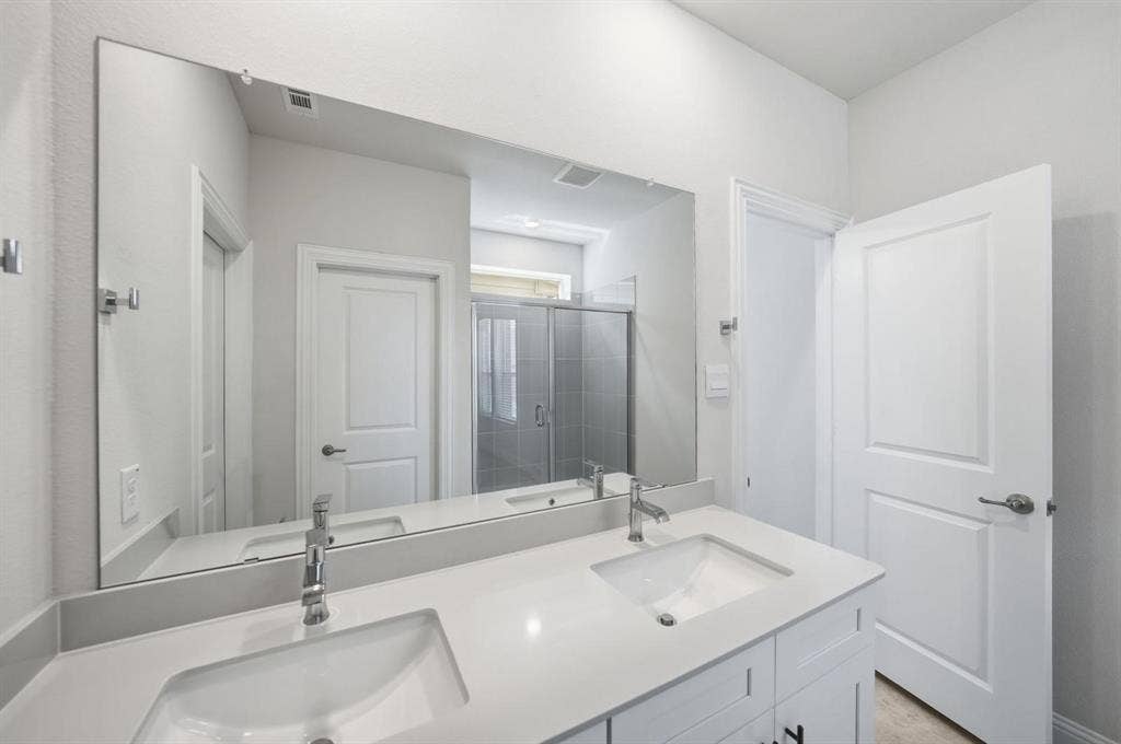 4532 Community Court, Plano, TX 75024 Dual undermount sinks with chrome faucets, expansive mirror, and a glass-enclosed shower