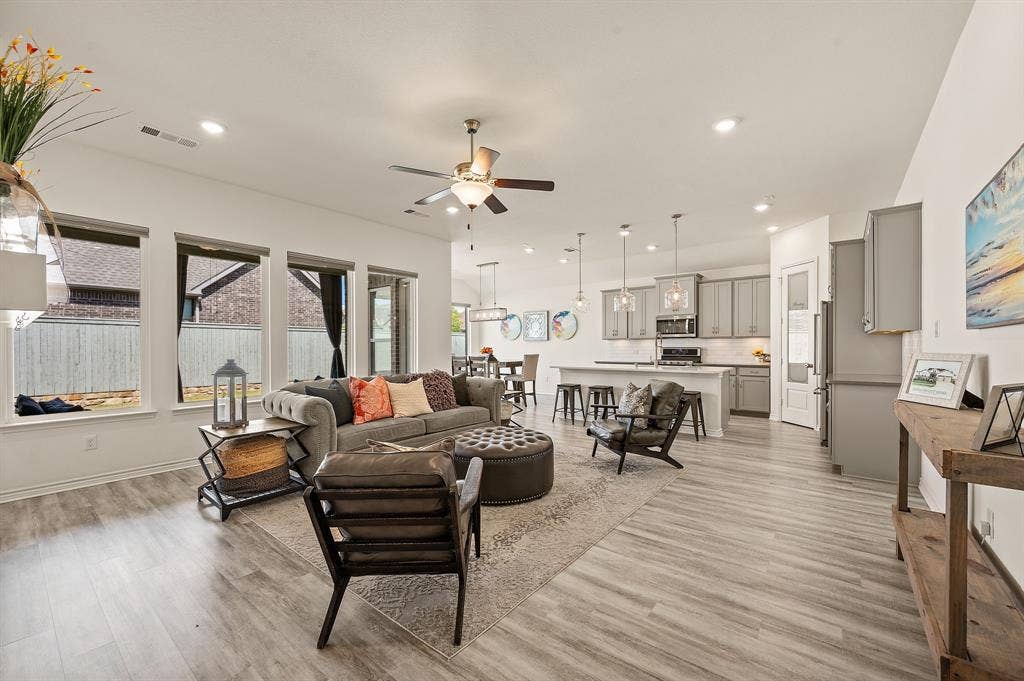 2900 Peekaboo Lane, Northlake, TX 76247 Open-concept living room featuring LVP flooring, recessed lighting, and beautiful windows that let in so much wonderful natural light!