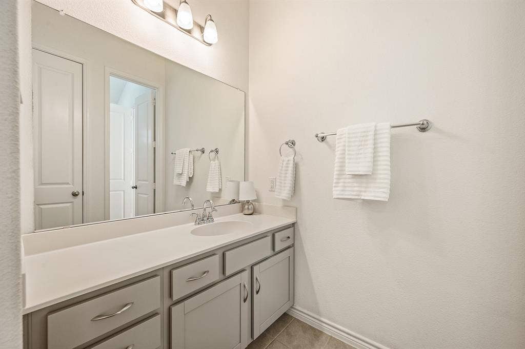 2900 Peekaboo Lane, Northlake, TX 76247 Built-in vanity with a single basin sink, light-toned countertop, and light gray cabinetry