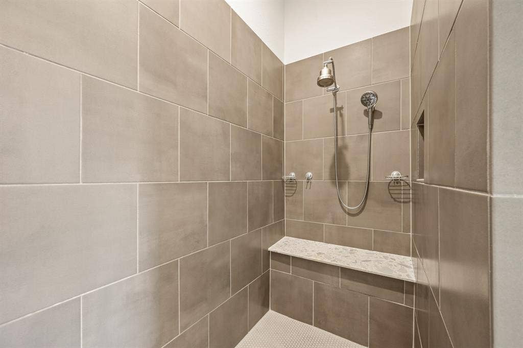 2900 Peekaboo Lane, Northlake, TX 76247 Over sized stand alone Shower featuring large wall tiling, a built-in shower bench with a stone top, and a recessed niche, tow shoer heads and a spa like shower to enjoy.