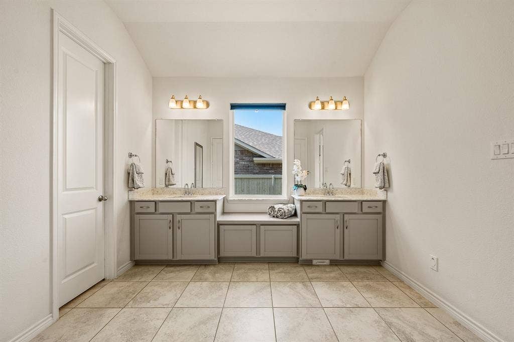 2900 Peekaboo Lane, Northlake, TX 76247 Dual vanity with integrated storage cabinetry, individual mirrors, and overhead light fixtures with more than enough space to enjoy your spa like primary bathroom.