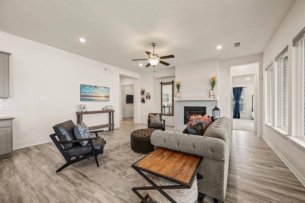 2900 Peekaboo Lane, Northlake, TX 76247 Recessed lighting, LVP flooring, a lovel fireplace with a beautiful tile surround, multiple windows letting in wonderful lighting and a ceiling fan...More than enough room for all your friends and family!