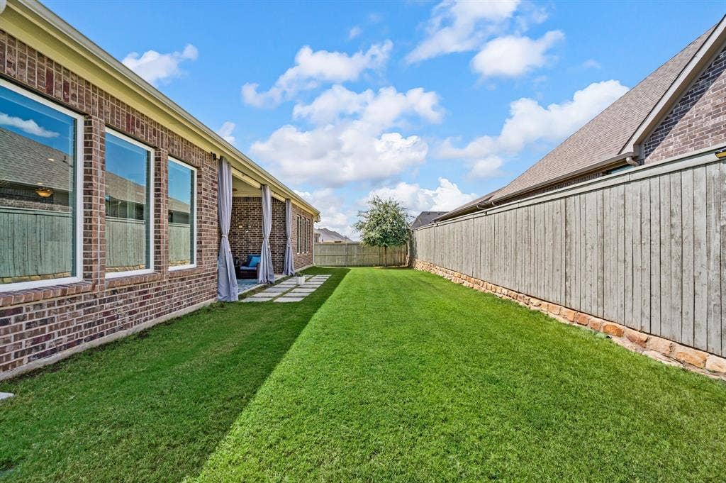 2900 Peekaboo Lane, Northlake, TX 76247 Expansive backyard with a fabulous manicured lawn, wonderful covered patio, and a wood fence with stone base...a perfect place to enjoy time with family and friends!