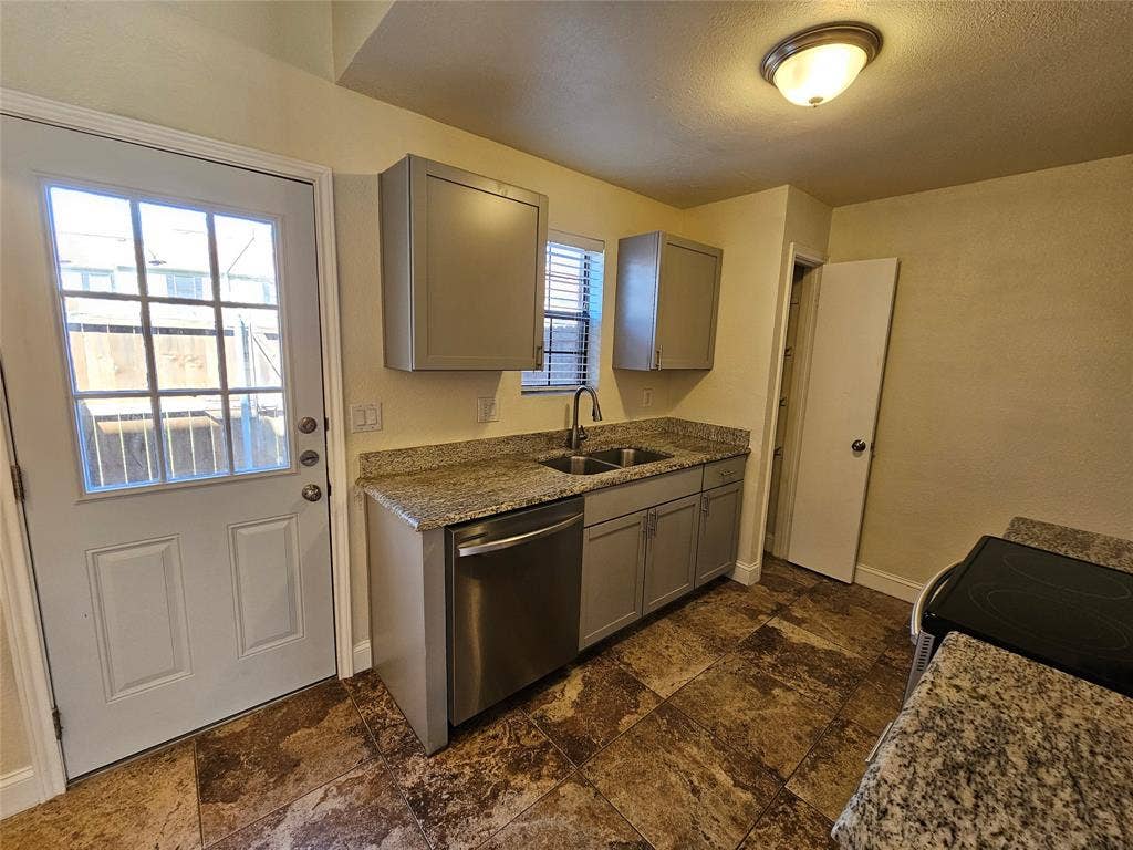 216 Samuel Boulevard, #j3, Coppell, TX 75019 Tile flooring, light-toned cabinetry, granite-style countertops, stainless steel dishwasher, and a glass-paneled door