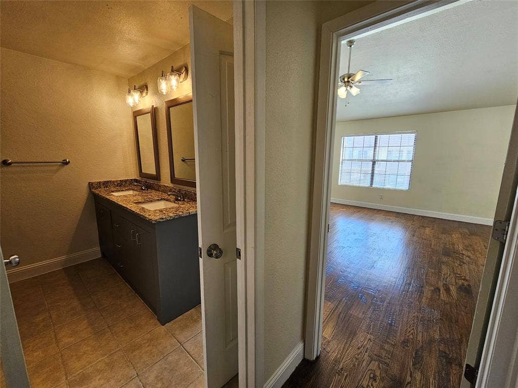 216 Samuel Boulevard, #j3, Coppell, TX 75019 Bathroom vanity with dual sinks, granite countertop, and tiled flooring