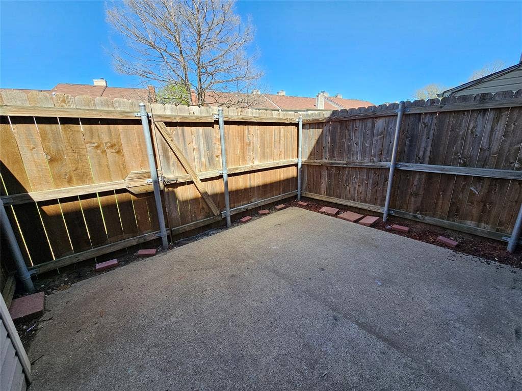 216 Samuel Boulevard, #j3, Coppell, TX 75019 Private concrete patio with wood fencing, a wood gate, and landscape edging