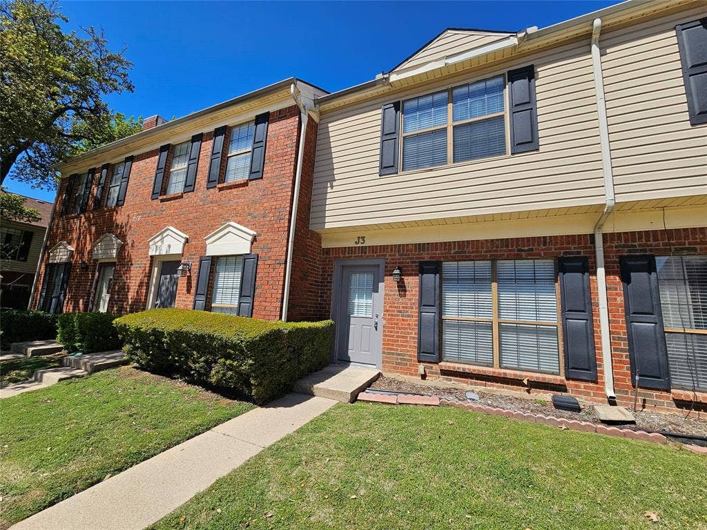 216 Samuel Boulevard, #j3, Coppell, TX 75019 Brick and siding exterior with dark shutters, featuring a manicured hedge and a paved walkway