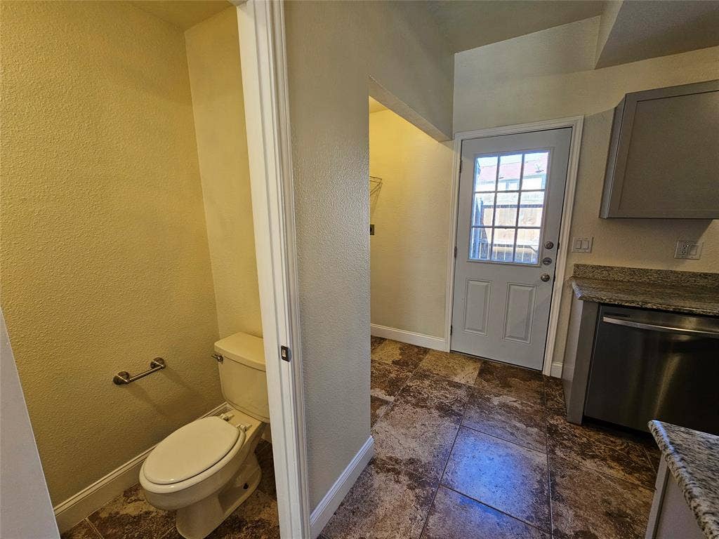 216 Samuel Boulevard, #j3, Coppell, TX 75019 Tiled flooring throughout, featuring a white paneled door with window panes, a stainless steel appliance, and stone countertops