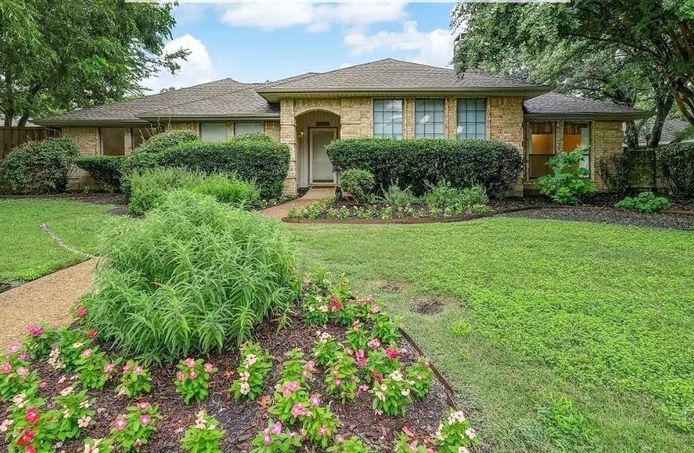 3717 Atrium Drive, Plano, TX 75075 Stone facade home with a shingle roof, mature landscaping, and a concrete pathway