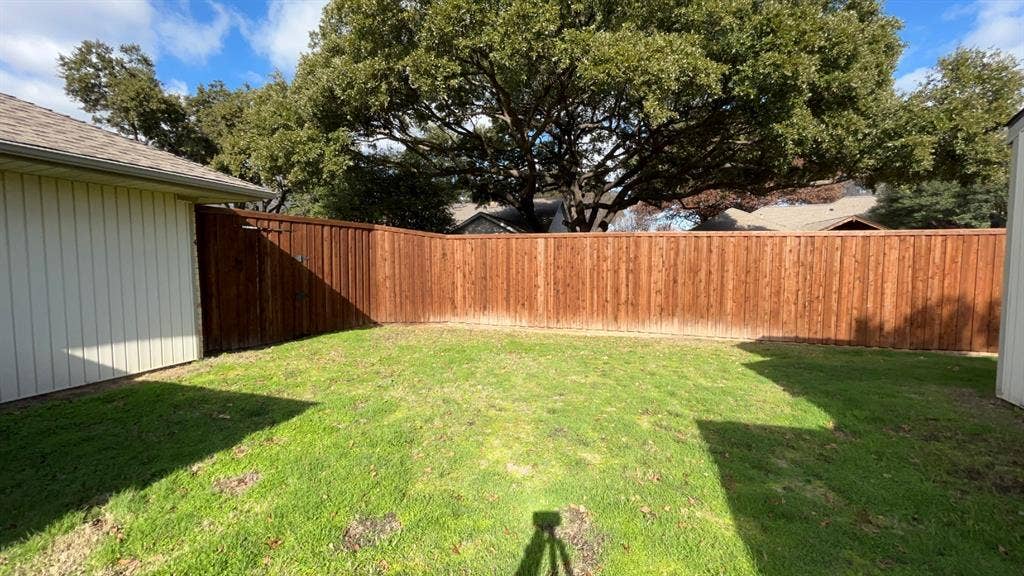 3717 Atrium Drive, Plano, TX 75075 Expansive backyard featuring a stained wood privacy fence and a manicured lawn