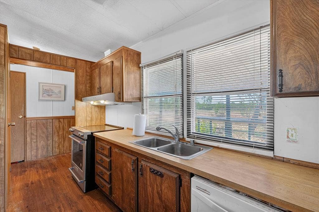 11929 County Road 950, Rockwall, TX 75087 Wood-finish flooring, wood paneling, stainless steel range, dual basin sink, and ample cabinet storage