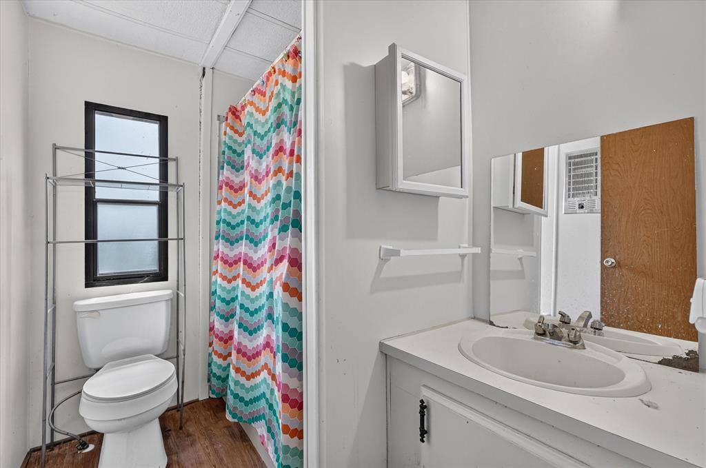 11929 County Road 950, Rockwall, TX 75087 White wall paint, wood-finish flooring, and white vanity with an integrated sink