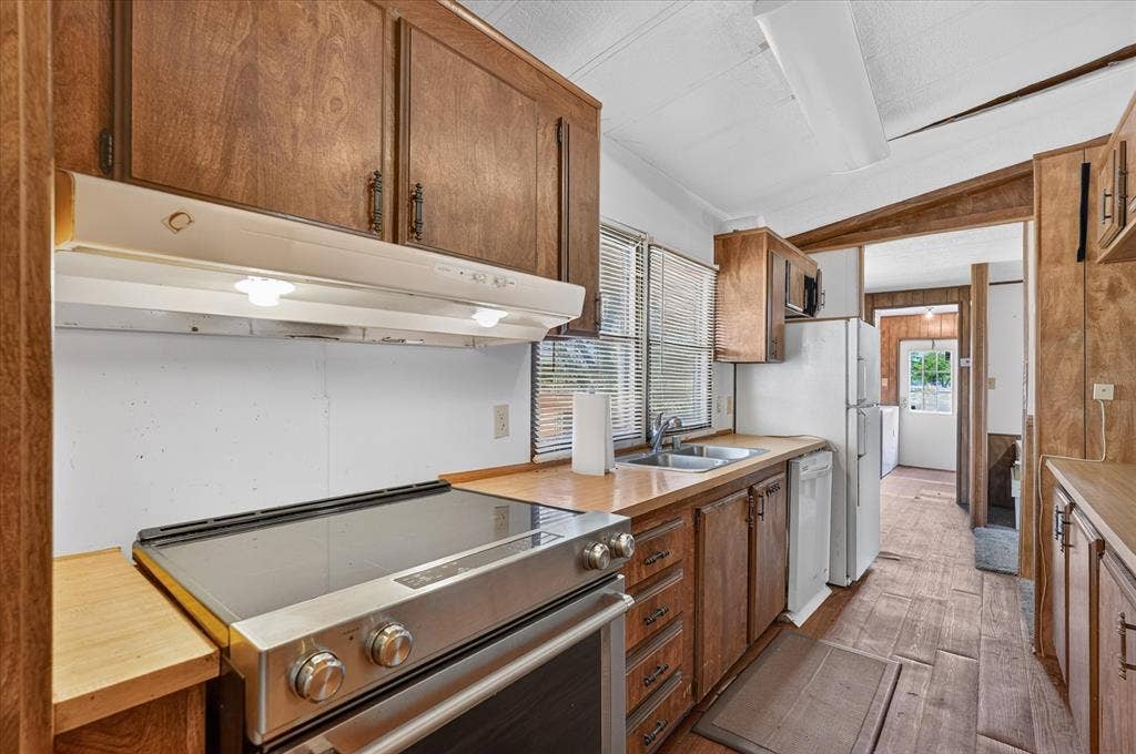 11929-1 County Road 950, Rockwall, TX 75087 Kitchen featuring wood-finish cabinetry, stainless steel range, and wood-finish flooring