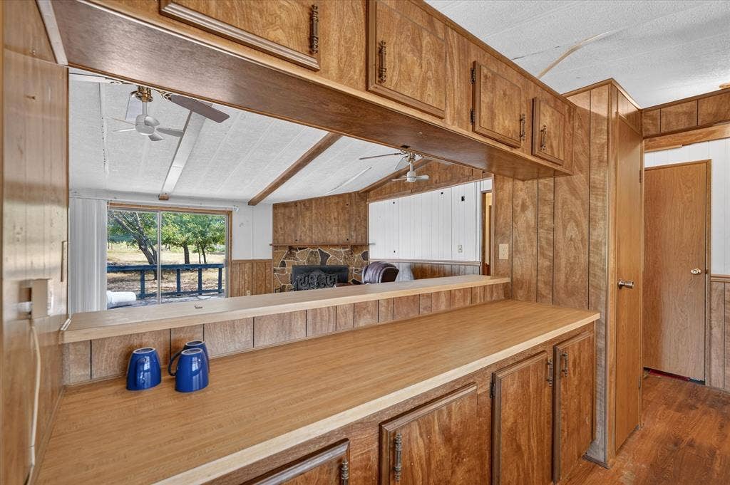 11929-1 County Road 950, Rockwall, TX 75087 Wood-finish cabinetry and paneling throughout, featuring a pass-through window with a wood-finish countertop