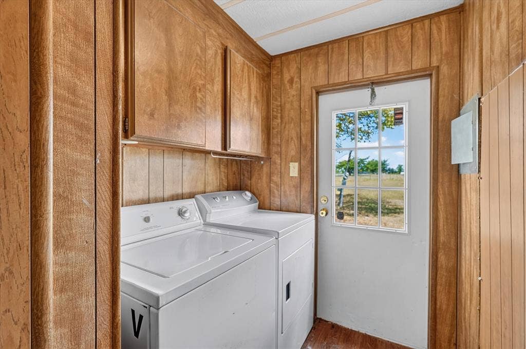 11929-1 County Road 950, Rockwall, TX 75087 Dedicated laundry area with wood-finish paneling, overhead wood-finish cabinetry, and a white exterior door with a divided light window