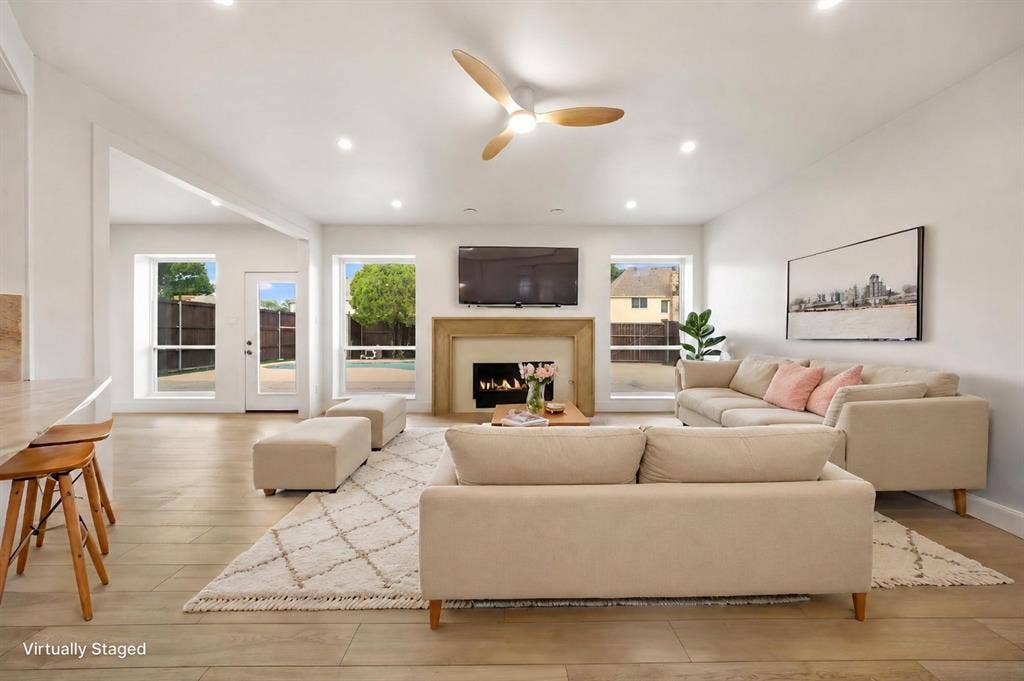 7504 Hughes Drive, Plano, TX 75024 Spacious living area featuring a fireplace with a stone surround, recessed lighting, wood-finish flooring, and a contemporary ceiling fan