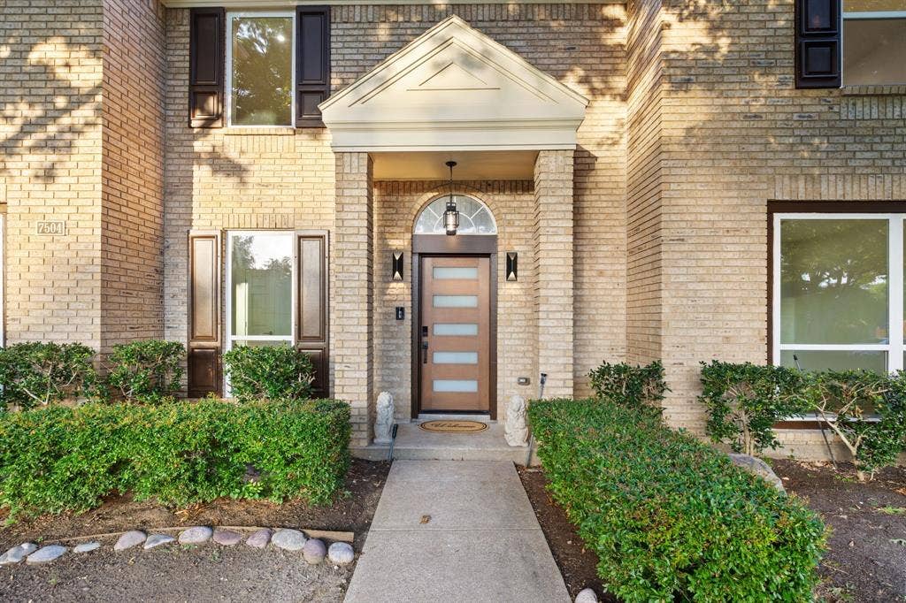 7504 Hughes Drive, Plano, TX 75024 Brick exterior with a covered entry featuring a transom window above the front door