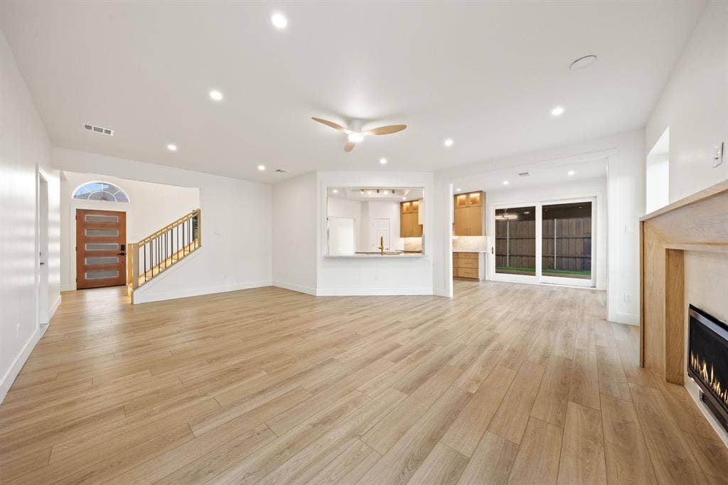 7504 Hughes Drive, Plano, TX 75024 Expansive living area with light wood-finish flooring, recessed lighting, and a modern ceiling fan