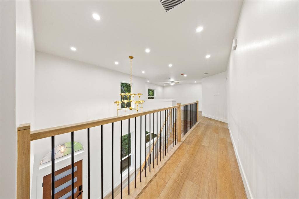7504 Hughes Drive, Plano, TX 75024 Upper-level hallway with wood-finish flooring, white walls, and recessed lighting