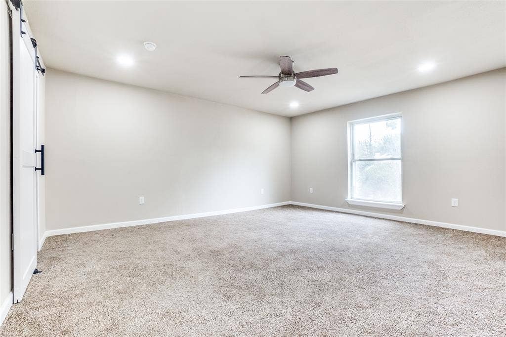 1904 Richland Drive, Richardson, TX 75081 Spacious room featuring neutral carpet, a single window, and a ceiling fan with integrated lighting