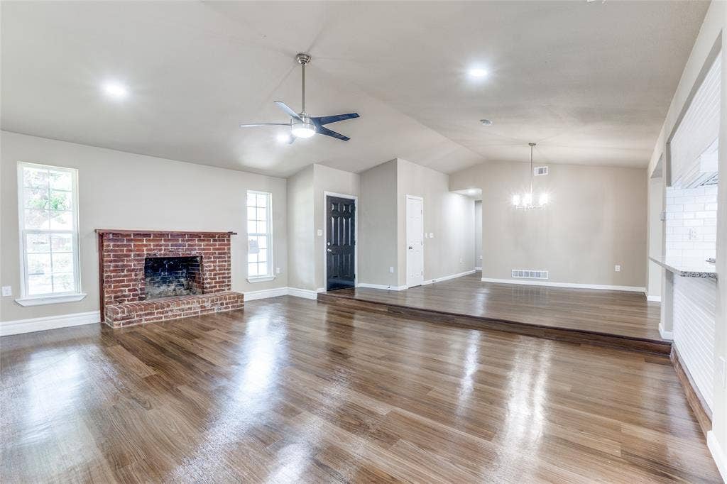 1904 Richland Drive, Richardson, TX 75081 Wood-finish flooring, brick fireplace, vaulted ceilings, recessed lighting, and a modern ceiling fan