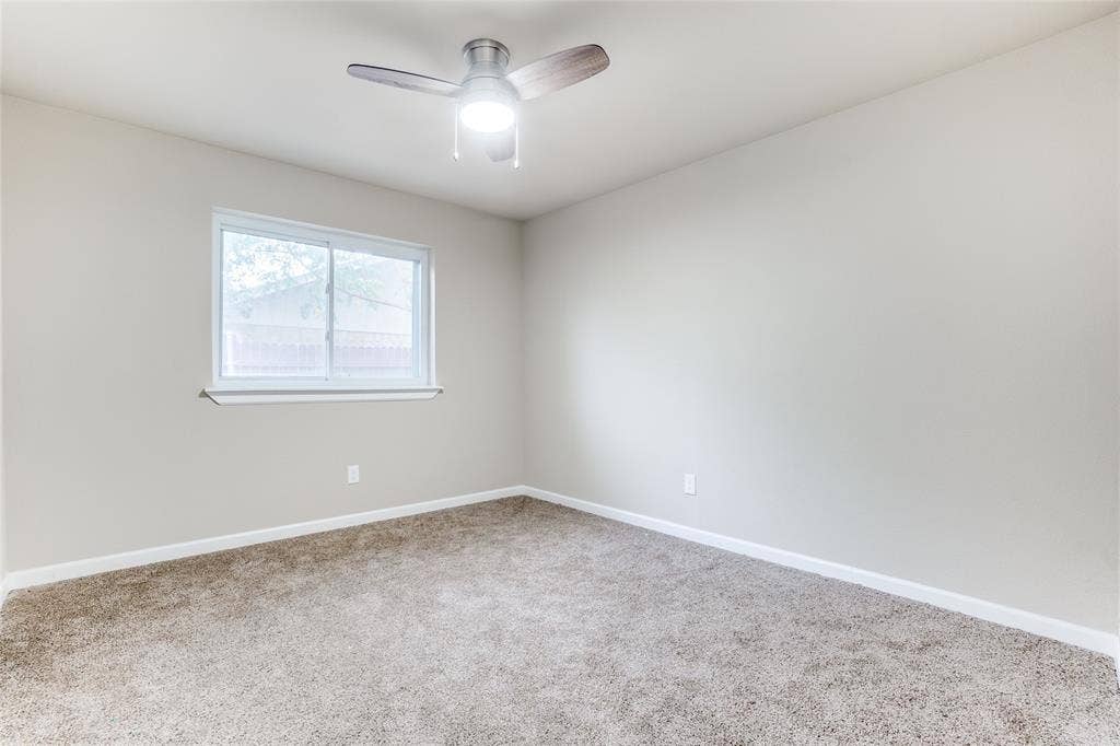 1904 Richland Drive, Richardson, TX 75081 Neutral wall color, ceiling fan with light fixture, carpeted flooring, and a large window