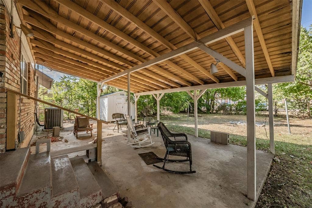1313 Killian Drive, Arlington, TX 76013 Covered patio with exposed wood ceiling, concrete flooring, and brick exterior