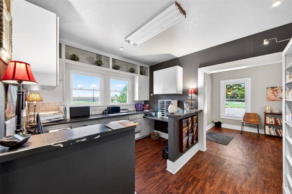 508 W Main Street, Allen, TX 75013 Wood-finish flooring, built-in shelving, white cabinetry, dark countertops, and light-colored wall paint